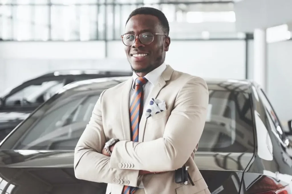 young black businessman on auto salon background car sale and rent concept